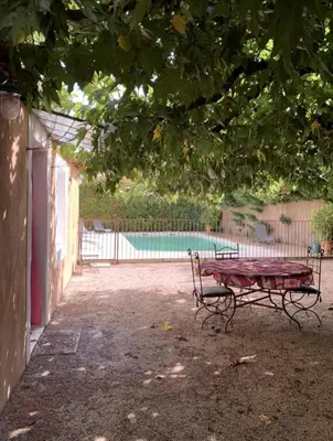a picnic table in front of a swimming pool at Bel appartement de vacances 6 personnes in Caumont-sur-Durance