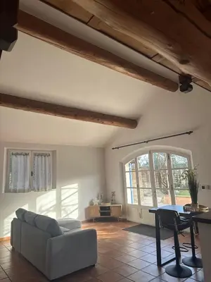 a kitchen with white cabinets and black appliances at VILLA DE LA ROQUE II - Loft in Eygalières