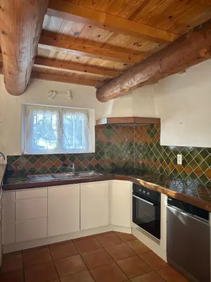 a kitchen with a table and a loft with a bed at VILLA DE LA ROQUE II - Loft in Eygalières