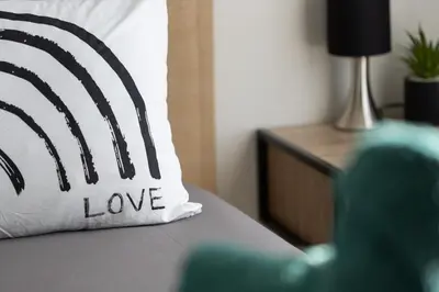 a pillow with the word love sits on a bed at Bella Vita Outdoor Jacuzzi in LʼIsle-sur-la-Sorgue