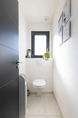 a bathroom with a toilet and a window at Bella Vita Outdoor Jacuzzi in LʼIsle-sur-la-Sorgue