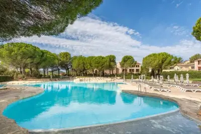 a swimming pool with blue water in a resort at La Bastide du Golfeur, Jardin et Piscine in Mallemort