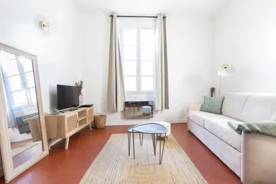 a living room with a white couch and a table at Modern studio Le Renoir - Center of city - WiFi in Aix-en-Provence