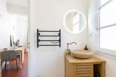 a bathroom with a sink and a table and a mirror at Modern studio Le Renoir - Center of city - WiFi in Aix-en-Provence