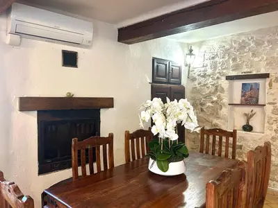 a dining room table with a vase of flowers on it at Charmante maison de village avec clim et parking à proximité d'Aix-en-Provence in Éguilles
