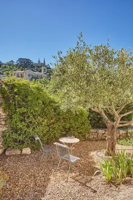 two chairs and a table and a tree at La Paulanne in Bonnieux