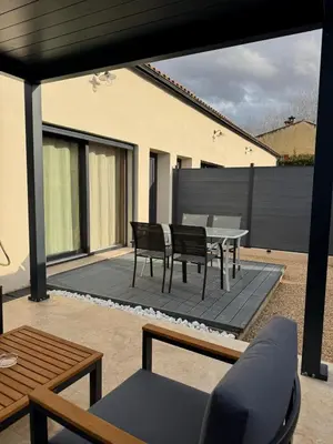 a patio with a table and chairs on a deck at Esprit Lubéron, La Lavande, logement entier in Le Thor