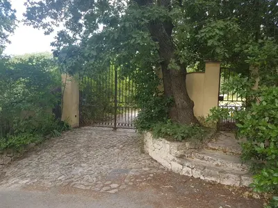 a tree with a fence and stairs next to a tree at Holiday House Teulon in Éguilles