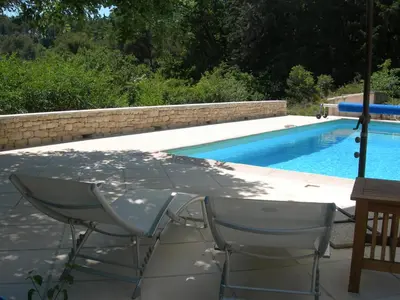 a table and chairs next to a swimming pool at Holiday House Teulon in Éguilles