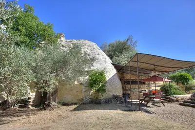 an old stone house with a tent and a picnic table at Bergerie provencale, 4 personnes, piscine in Gordes