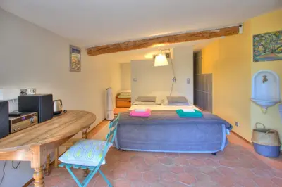 a bedroom with a large bed and a table and chair at Bergerie provencale, 4 personnes, piscine in Gordes