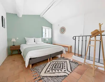 a bedroom with a king sized bed and a ladder at Maison rénovée avec terrasse et parking privé in Mallemort