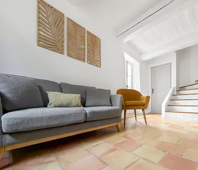 a living room with a couch and a tv on the wall at Maison rénovée avec terrasse et parking privé in Mallemort