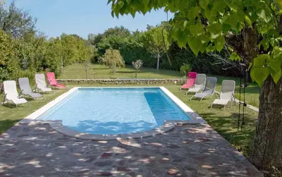 a swimming pool with lounge chairs and a tree at Mas Provençal - 300 m2 - 7 chambres in Cavaillon