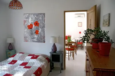 a bedroom with a bed and a kitchen with a table at Mas Provençal - 300 m2 - 7 chambres in Cavaillon