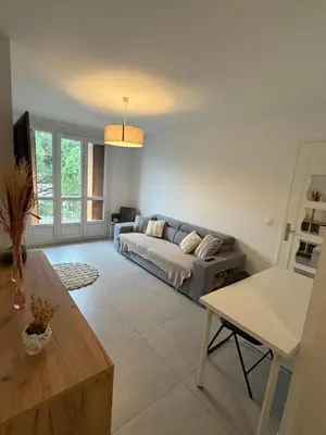 a living room with a couch and a table at Appartement moderne 3 chambres avec parking sécurisée in Aix-en-Provence