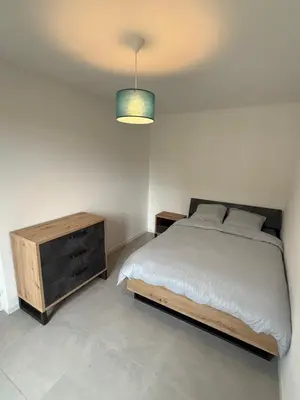 a bedroom with a bed and a wooden dresser at Appartement moderne 3 chambres avec parking sécurisée in Aix-en-Provence