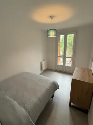 a white bedroom with a bed and a window at Appartement moderne 3 chambres avec parking sécurisée in Aix-en-Provence
