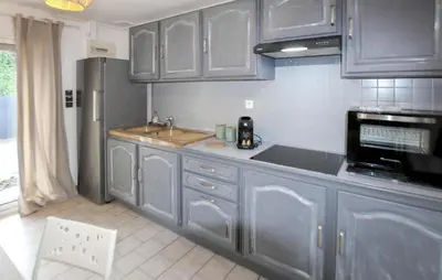 a kitchen with blue cabinets and a sink and a refrigerator at Amazing Home In Lauris in Lauris