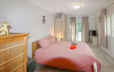 a bedroom with a pink bed with two stuffed animals on it at Amazing Home In Lauris in Lauris