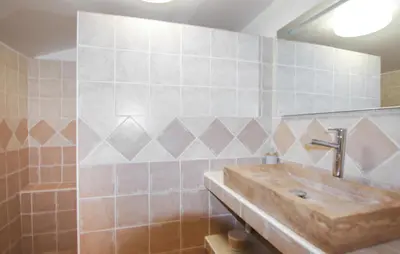 a bathroom with a sink and a tiled wall at Amazing Home In Lauris in Lauris