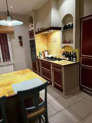 a kitchen with a table and a stove top oven at Farm House, 10 min d'Avignon in Jonquerettes