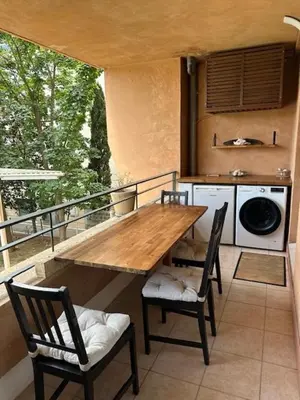 a wooden table and chairs on a balcony at Calme T2, Wifi, Proche centre et sites culturels, Vue magnifique in Aix-en-Provence