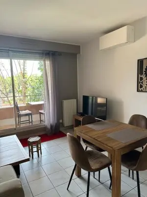 a living room with a wooden table and chairs at Calme T2, Wifi, Proche centre et sites culturels, Vue magnifique in Aix-en-Provence