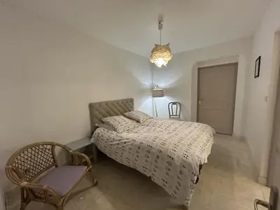 a bedroom with a bed and a chair and a lamp at Maison Satine in Noves