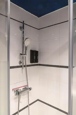 a shower in a bathroom with white tiles at Appartement Aix centre ville in Aix-en-Provence