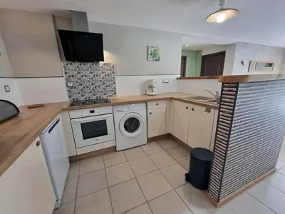 a kitchen with a washing machine and a washer at Gîtes de la Coupière Le Laurier in Aubenas-les-Alpes