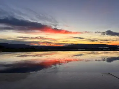 a sunset with a reflection of the sky in a pond at 180 Grand Luberon Gordes vue panoramique in Gordes