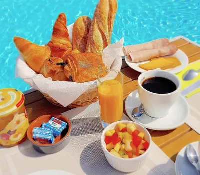 a table with a basket of bread and a cup of coffee at Domaine De Pradaous in Reillanne