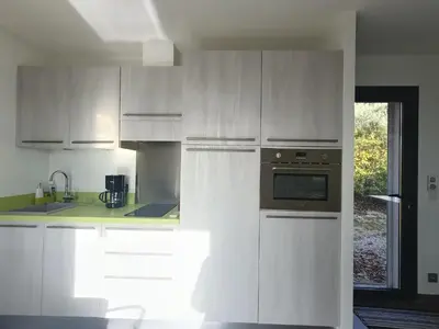 a kitchen with white cabinets and an oven at Villa ChloLéa in Caromb