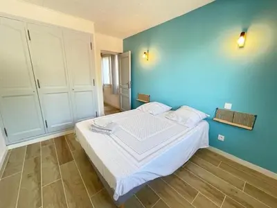 a bedroom with a large bed with a blue wall at La Treille cozy villa basement in Provence in Sainte-Tulle