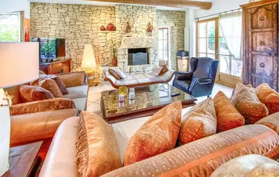 a living room with couches and a stone wall at Maison Avec Piscine Privée in Villars