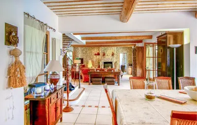 a living room with a table and a dining room at Maison Avec Piscine Privée in Villars