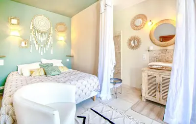 a bedroom with a white bed and a bathroom at Maison Avec Piscine Privée in Villars
