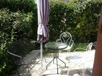an umbrella and a table and chairs on a patio at Holiday Home by Interhome in Pierrevert