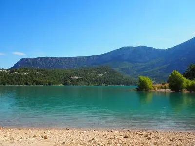 a view of a lake with mountains in the background at Holiday Home Charmantes Landhaus mit Garten by Interhome in Pierrevert