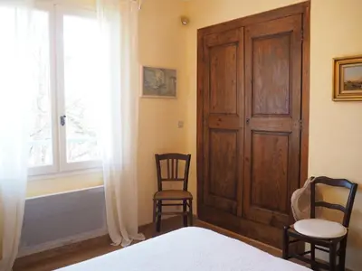 a bedroom with a bed and two chairs and a window at Holiday Home Charmantes Landhaus mit Garten by Interhome in Pierrevert