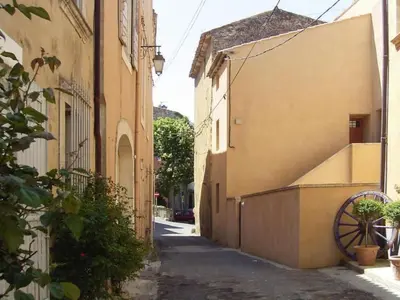 an alley with a building and a wheel next to it at Apartment Morard - Bonnieux Appt Les Ocres by Interhome in Bonnieux