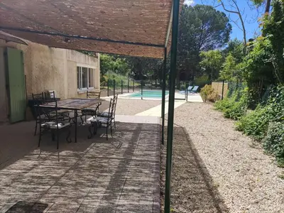 a patio with a table and chairs in the shade at Holiday Home Villa Roche en Provence Süd Luberon by Interhome in Ansouis