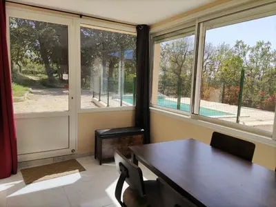 a dining room with a table and two windows at Holiday Home Villa Roche en Provence Süd Luberon by Interhome in Ansouis