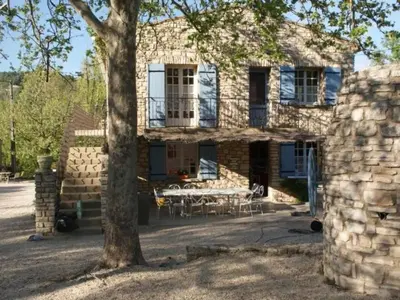 a stone house with a tree in front of it at Holiday Home Schöne provenzalische Villa Les Carlets mit Pool by Interhome in Saignon