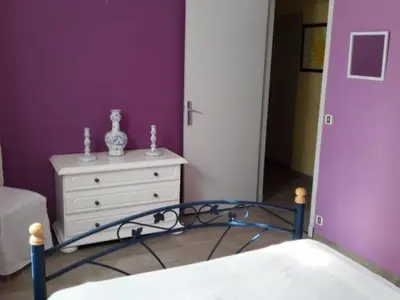 a bedroom with a bed and a dresser and purple walls at Holiday Home Schöne provenzalische Villa Les Carlets mit Pool by Interhome in Saignon