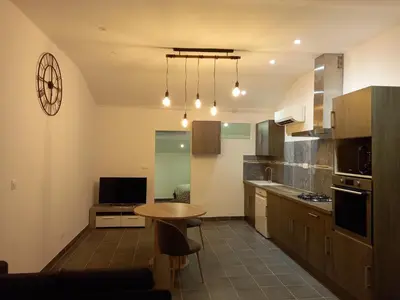 a kitchen with a table and a small table in it at Apartment Valentins Gîte Moulin de Tartay in Avignon by Interhome in Avignon
