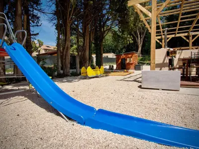 a blue slide in a playground at Apartment Leonie's Gîte Moulin de Tartay in Avignon by Interhome in Avignon