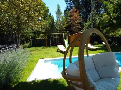 a swing in a yard next to a pool at Apartment Leonie's Gîte Moulin de Tartay in Avignon by Interhome in Avignon