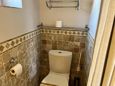 a bathroom with a toilet and a tiled wall at Holiday Home Das Atelier im Mas Naste by Interhome in Eygalières